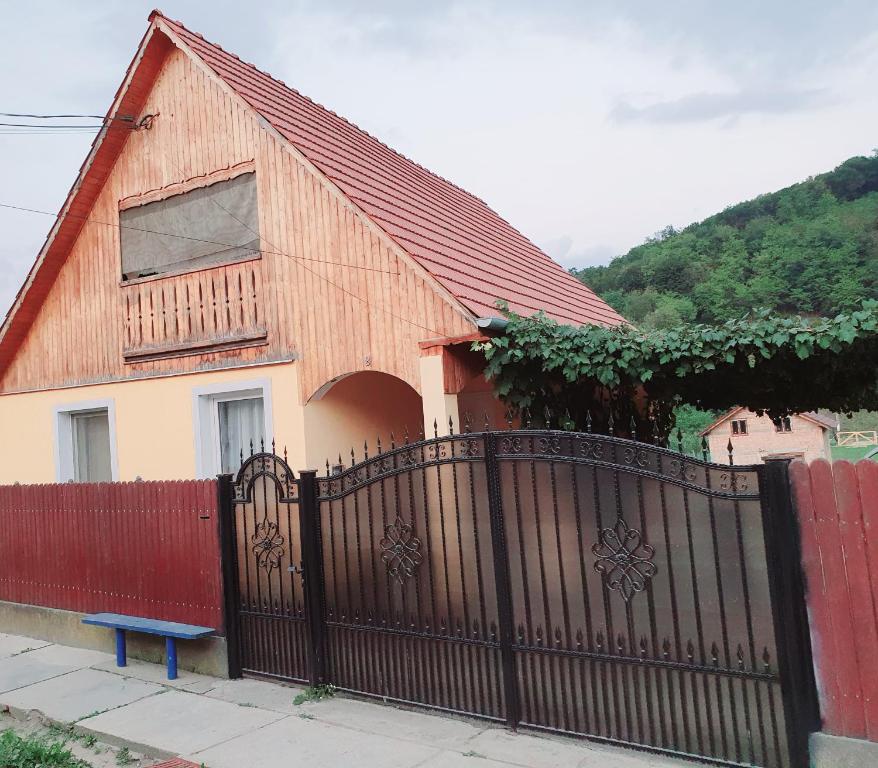 a house with a red fence and a blue bench at Casa Maria in Mălîncrav