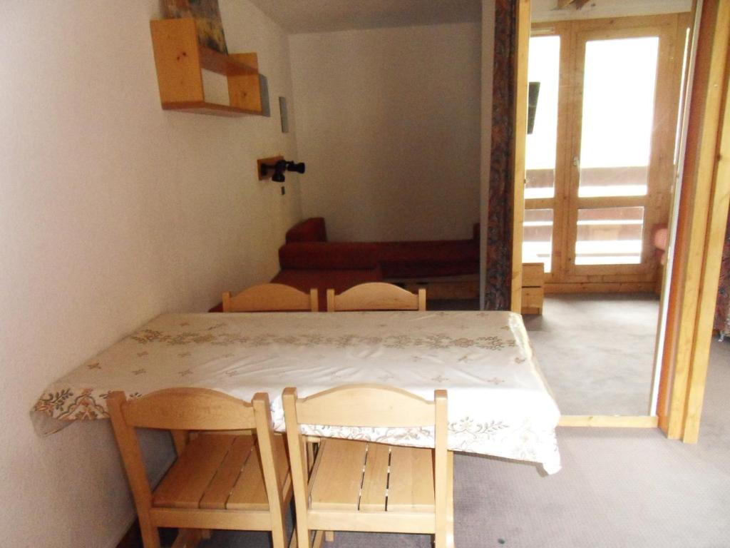 stół i krzesła w pokoju z drzwiami w obiekcie travelski home classic - Résidence 3000 w mieście La Plagne