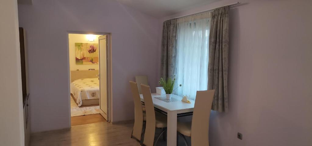 a room with a table and chairs and a bedroom at Апартамент Заря in Haskovo