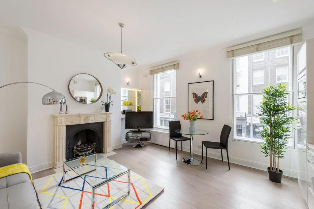 a living room with a fireplace and a table and chairs at Marylebone - Crawford Street by Viridian Apartments in London