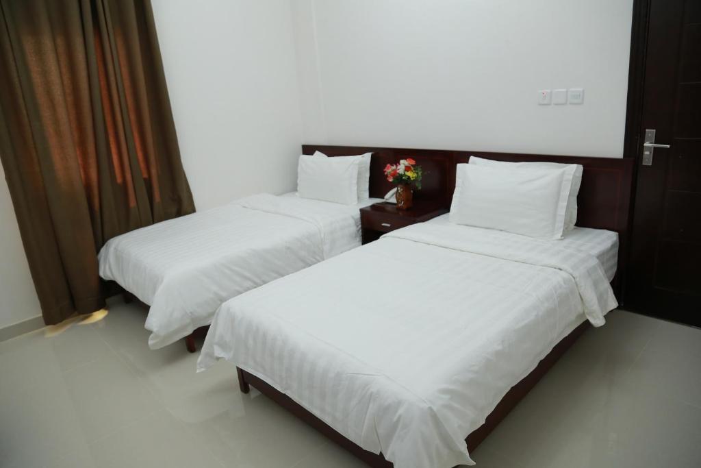 2 letti in camera d'albergo con lenzuola bianche di Al Basateen Hotel Rumays a Rumays
