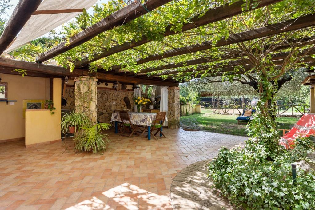 un patio con una pérgola de madera y una mesa en Villa Teresa 3 Abitaz Indipend Ti, en Bari Sardo
