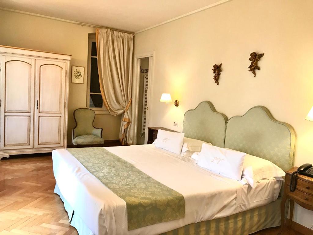 A bed or beds in a room at La Vittoria Boutique Hotel