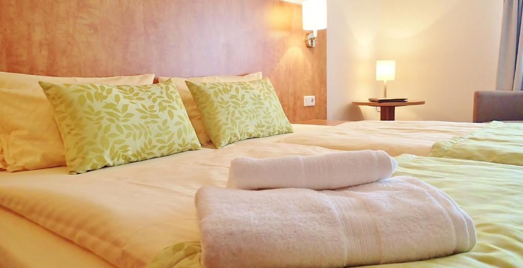 a large white bed with a towel on it at Hotel Mingarden in Düsseldorf