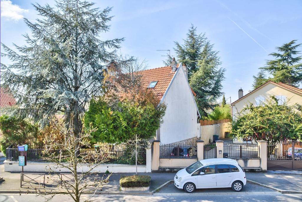 a white car parked in front of a house at Promotion du Jour - Studio Le Palmier in Deuil-la-Barre