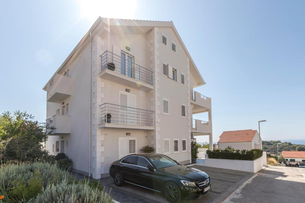 a black car parked in front of a white building at Hvar de luxe apartments 1 in Hvar