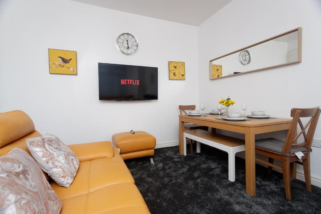 a living room with a couch and a table at AMIRI HOUSE APARTMENTs in Leeds