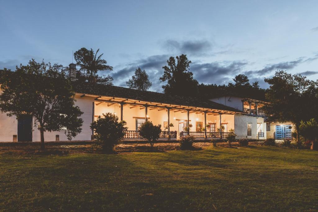 un gran edificio blanco con árboles delante de él en Hacienda Pisoje, en Popayán