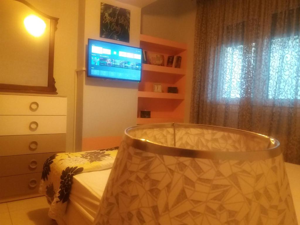 a bedroom with a bed and a tv and a dresser at Apartment with Balcony and Parking in Kavala