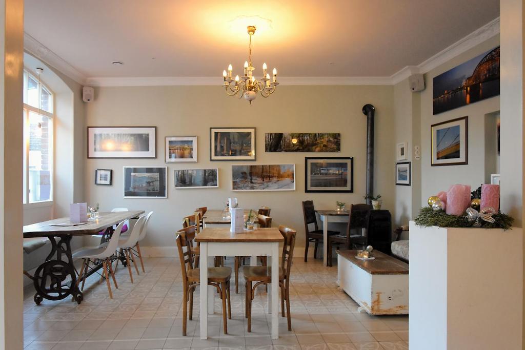 une salle à manger avec des tables et des chaises ainsi qu'un lustre dans l'établissement Alte Schreinerei Boutique Hotel, à Cologne