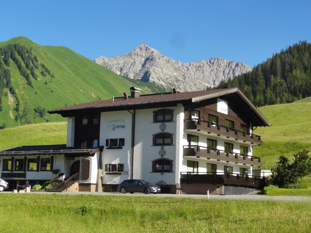 um grande edifício com uma montanha ao fundo em Quartier Severin em Berwang