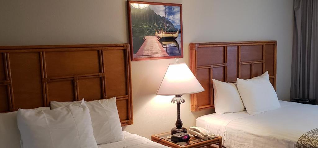 a hotel room with two beds and a lamp at Imperial Hawaii Resort in Honolulu