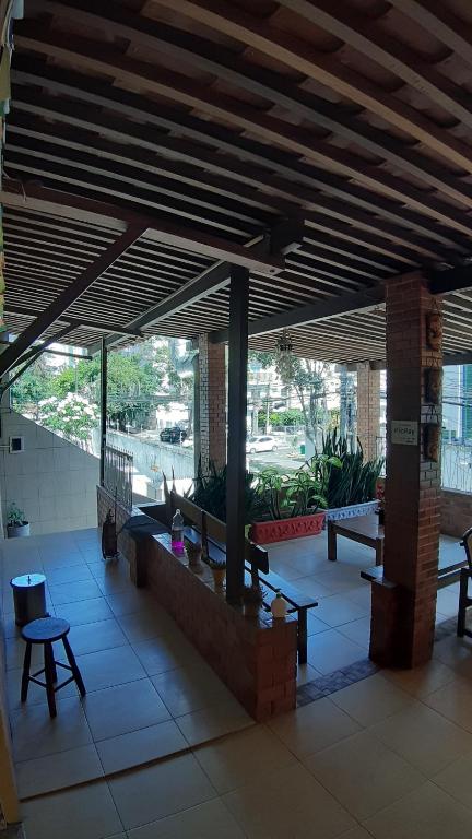 a lobby with benches and tables in a building at Piratas do Sol Hostel in Recife