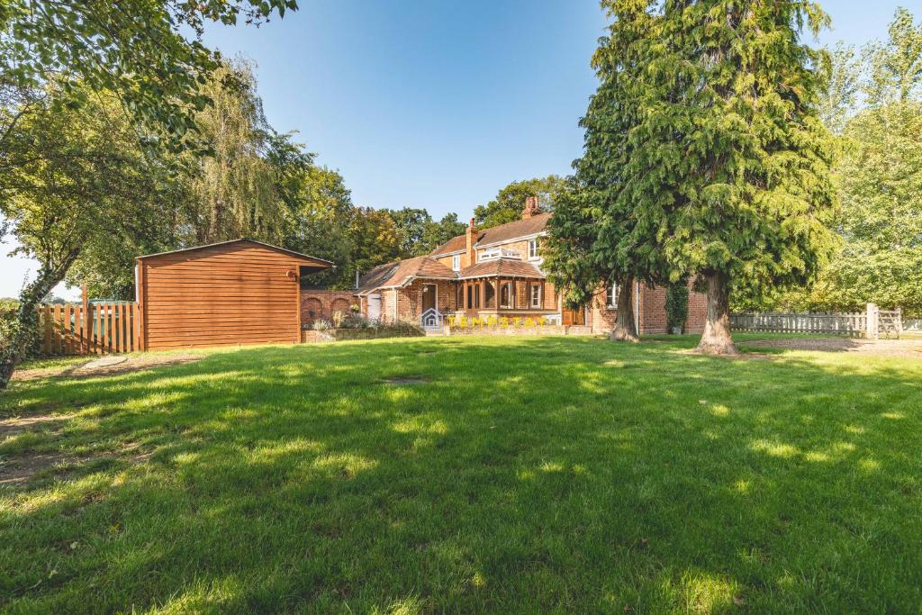 um grande quintal com uma casa e uma árvore em Chestnut Cottage - Stunning Countryside Views! PARKING, 4 BED, 3 BATHROOMS em White Waltham