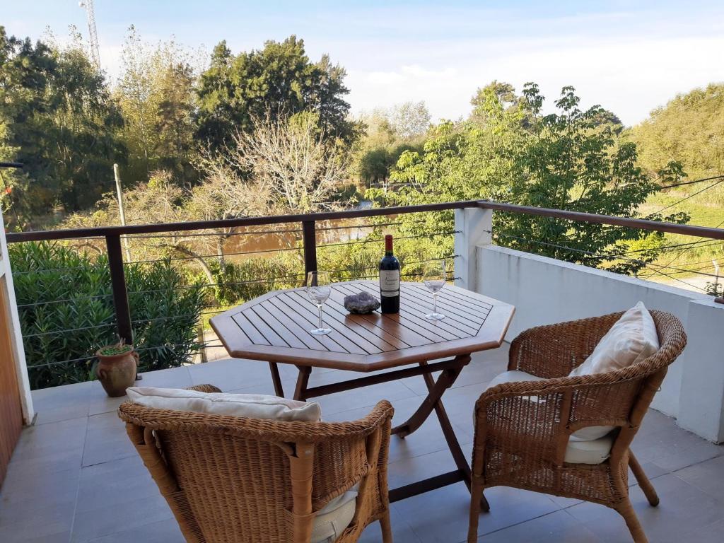 a table with a bottle of wine on a balcony at Duplex Rio Lujan CUBE in Belén de Escobar