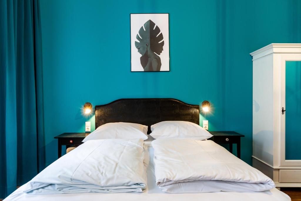 a blue bedroom with a bed with white pillows at SmartHotel Mystique Self check-in in Bad Homburg vor der Höhe