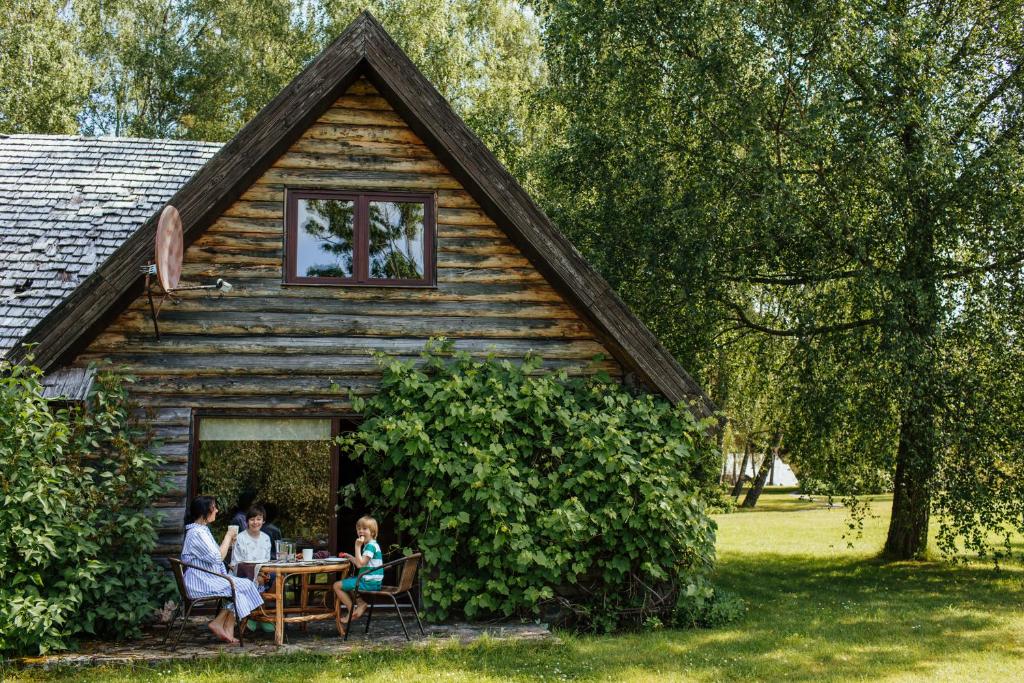 un gruppo di persone seduti a un tavolo fuori da una cabina di Hunter's Lodge a Padure