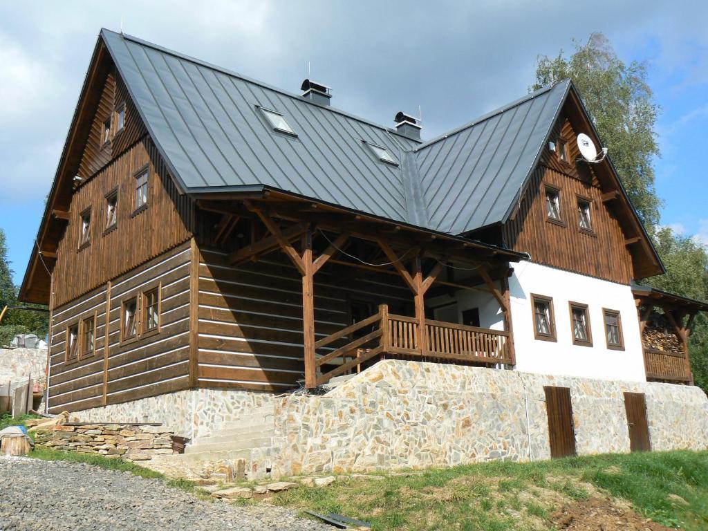 ein großes Holzhaus mit schwarzem Dach in der Unterkunft Rokytnice 434 in Rokytnice nad Jizerou