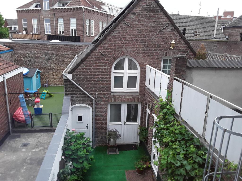a brick house with a white door and a yard at Singelachterhuis Roermond in Roermond