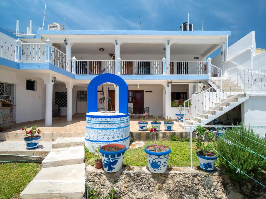 a house with blue and white pots in front of it at Hotel Casa Poblana in Bacalar