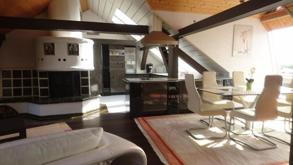 een keuken en een woonkamer met een tafel en stoelen bij Penthouse Himmelreich großzügige Maisonette auf 152 qm mit Klima & Kamin in Senftenberg