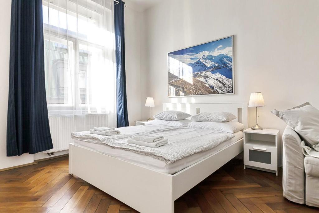 a white bedroom with a bed and a window at Aparthotel Wenceslas in Prague