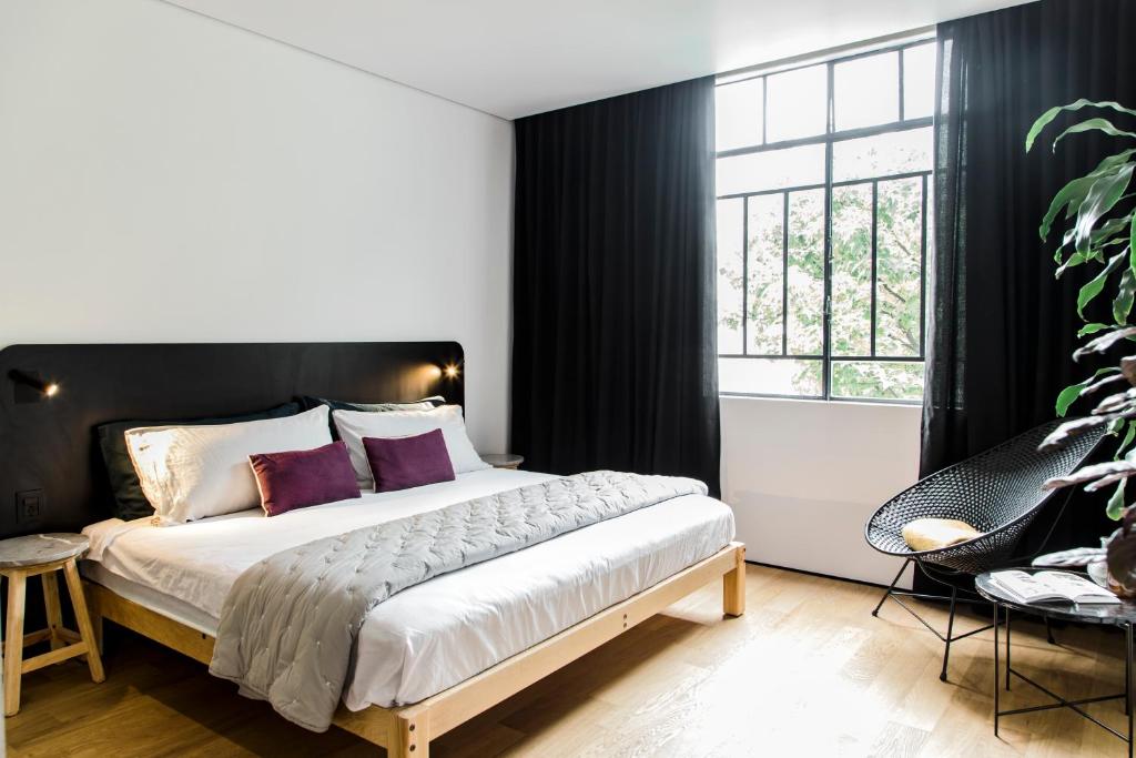 a bedroom with a bed and a large window at Hotel Itto Condesa in Mexico City