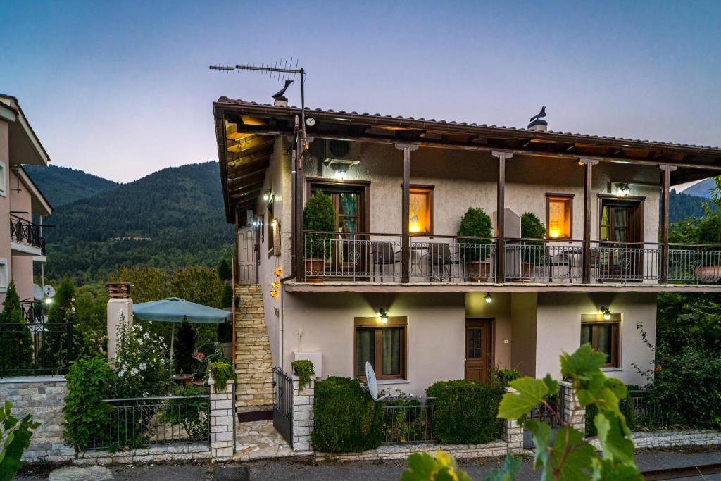 een groot huis met een balkon en bergen op de achtergrond bij Studio Iviscos in Mikrón Khoríon
