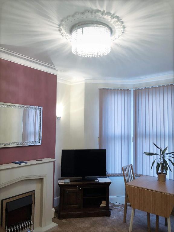 a living room with a fireplace and a television at Richmond Luxury flat Fabulous location in Southend-on-Sea