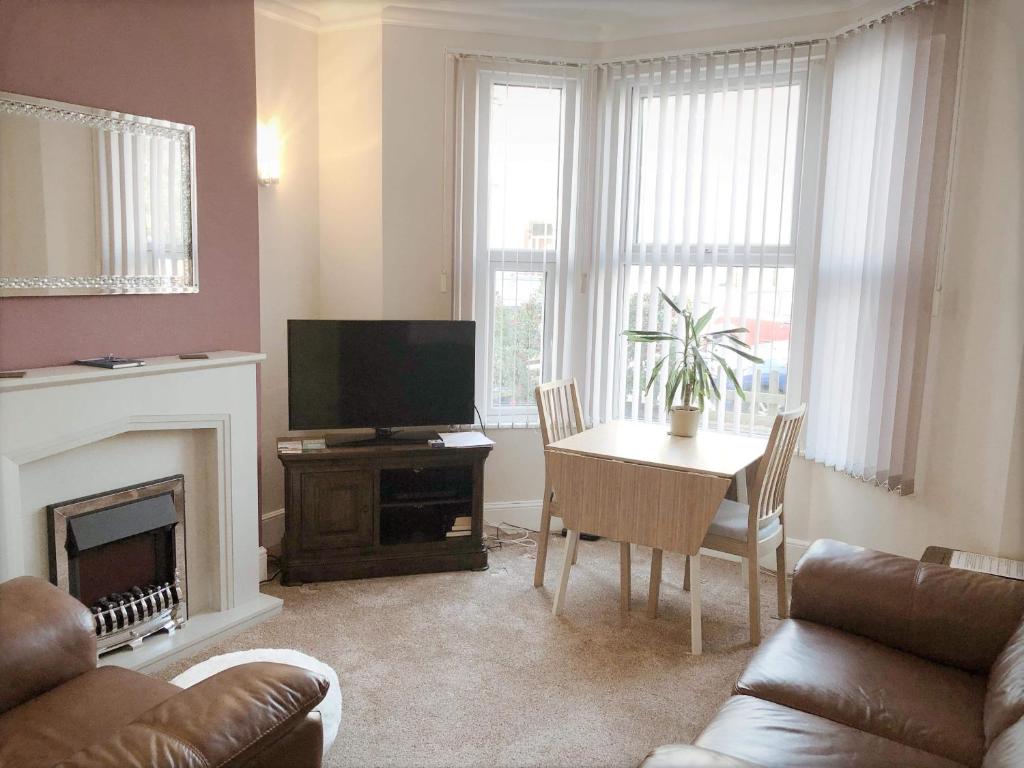 uma sala de estar com uma televisão e uma mesa com uma cadeira em Richmond Luxury flat Fabulous location em Southend-on-Sea
