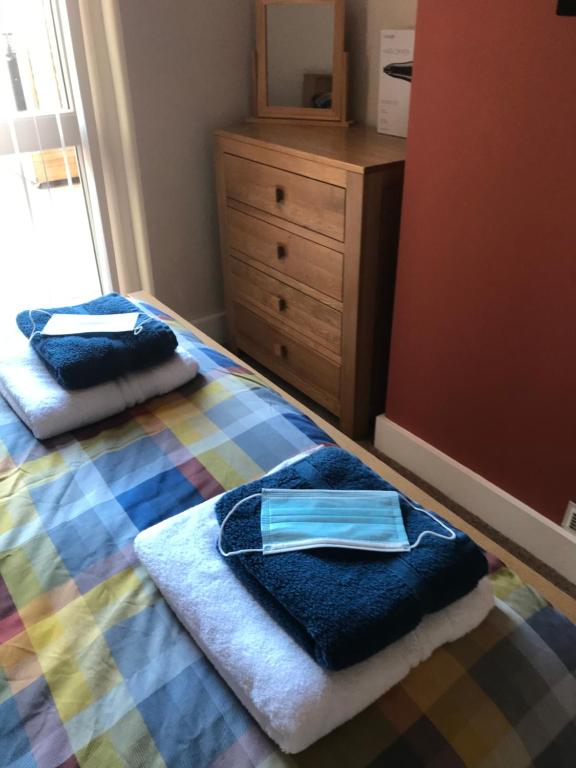 a bedroom with a bed with towels and a dresser at Richmond Luxury flat Fabulous location in Southend-on-Sea