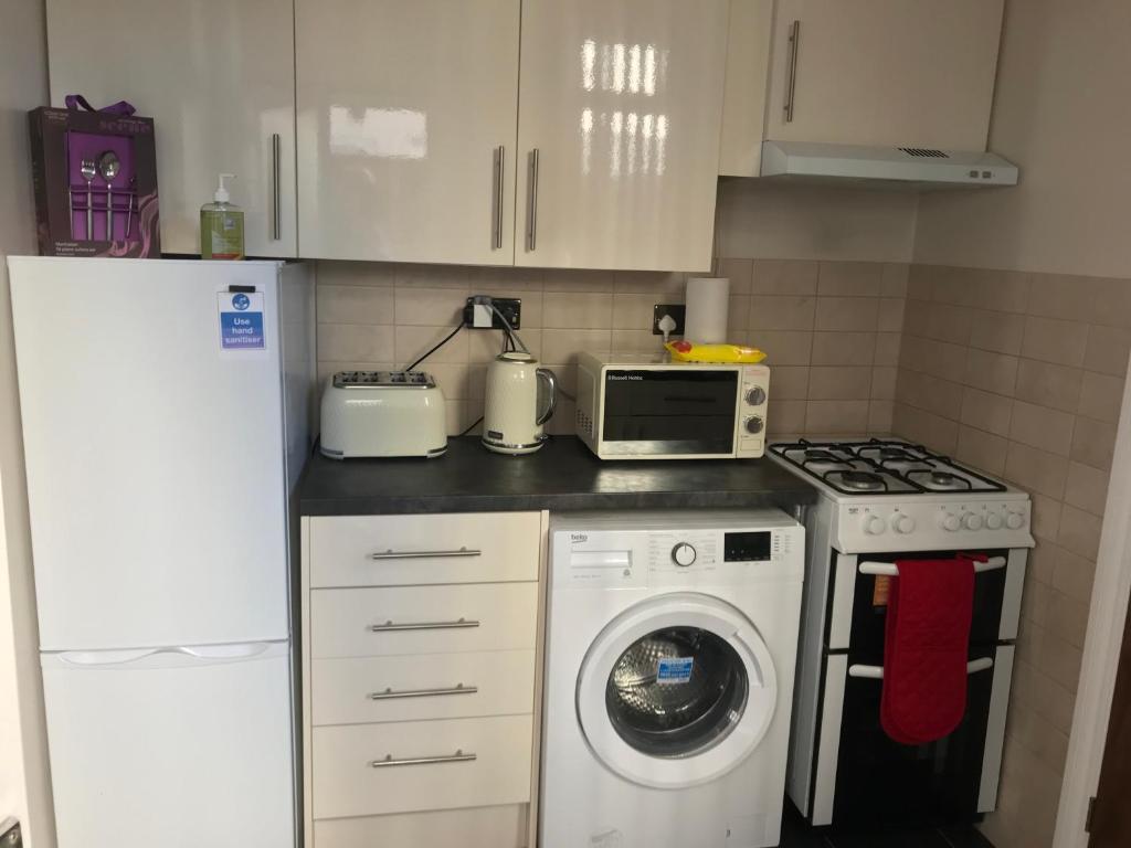 a kitchen with a washing machine and a microwave at Richmond Luxury flat Fabulous location in Southend-on-Sea