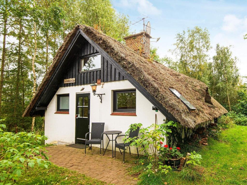 um pequeno chalé com telhado de palha em One-Bedroom Holiday home in Ejstrupholm em Ejstrup