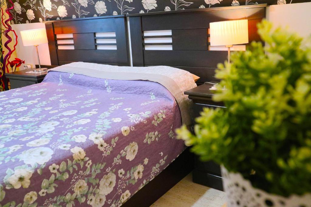 a bedroom with a bed and two night stands with two lamps at HAPPY ROOM in Granadilla de Abona