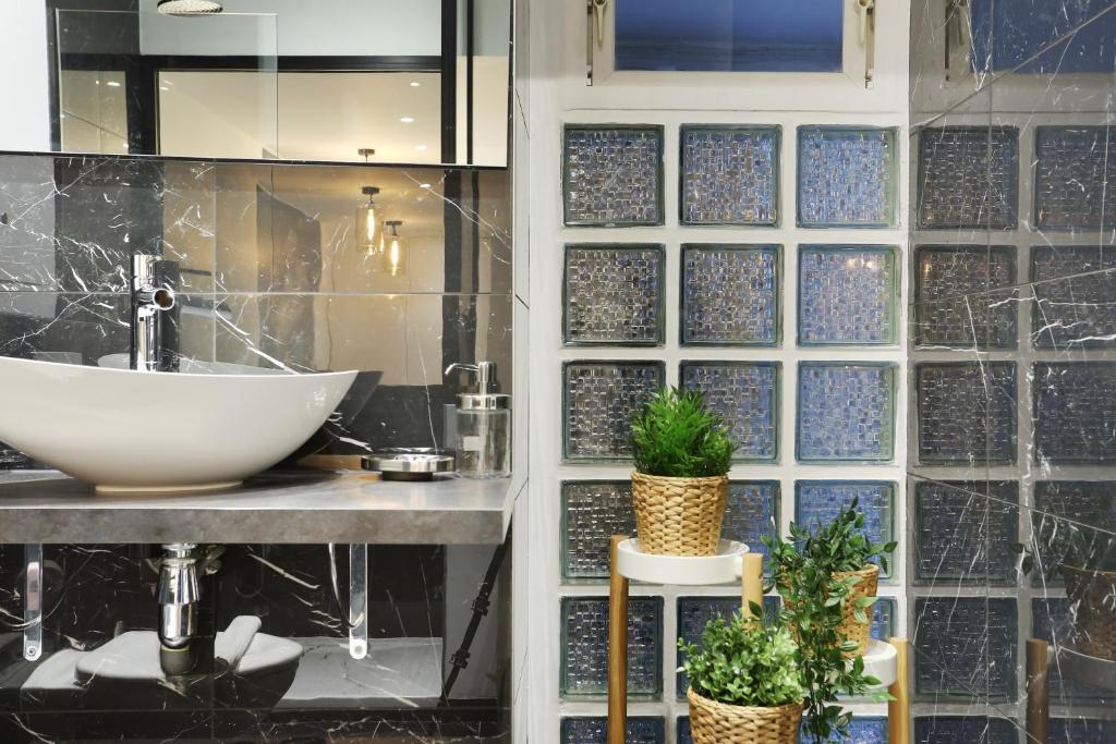a bathroom with a sink and a glass wall at Rent a Room - Apartment St Honore in Paris