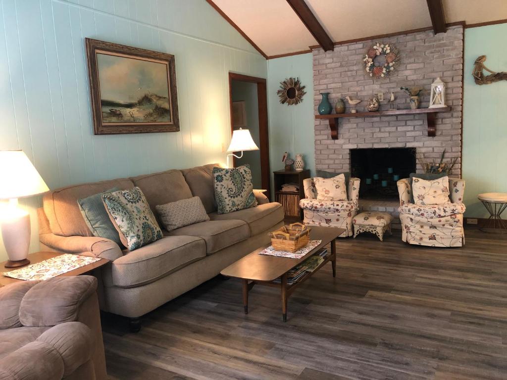 a living room with a couch and a fireplace at DIXIES RETREAT by Jekyll Realty in Jekyll Island