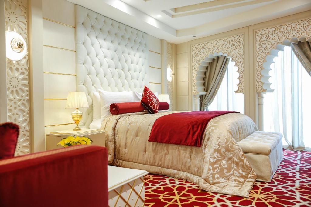 كراون بلازا كويت الثريا سيتي في الكويت: غرفة نوم بسرير كبير مع بطانية حمراء