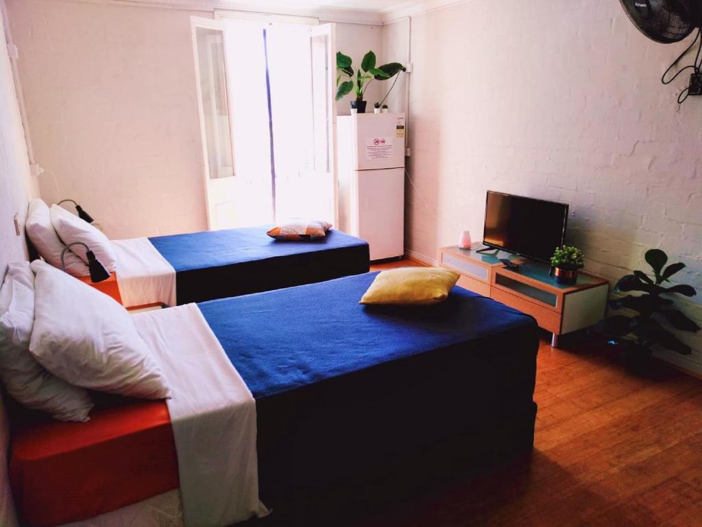 Una habitación con dos camas y un televisor. en Zen Harmony House Sydney, en Sídney
