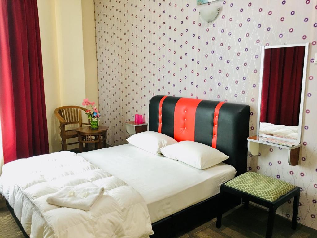 a bedroom with a bed with a colorful headboard at Hotel Bestari in Malacca