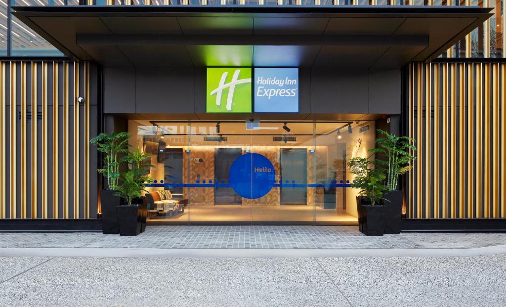 a store front with two potted plants in front of it at Holiday Inn Express Sydney Airport, an IHG Hotel in Sydney