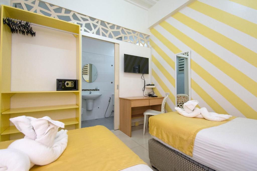 a hotel room with two beds and a bathroom at Alicia Tower Residences in Cebu City