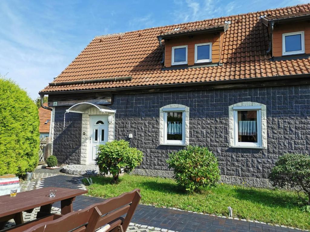a stone house with a red roof at Ferienwohnung Ritha in Sandberg