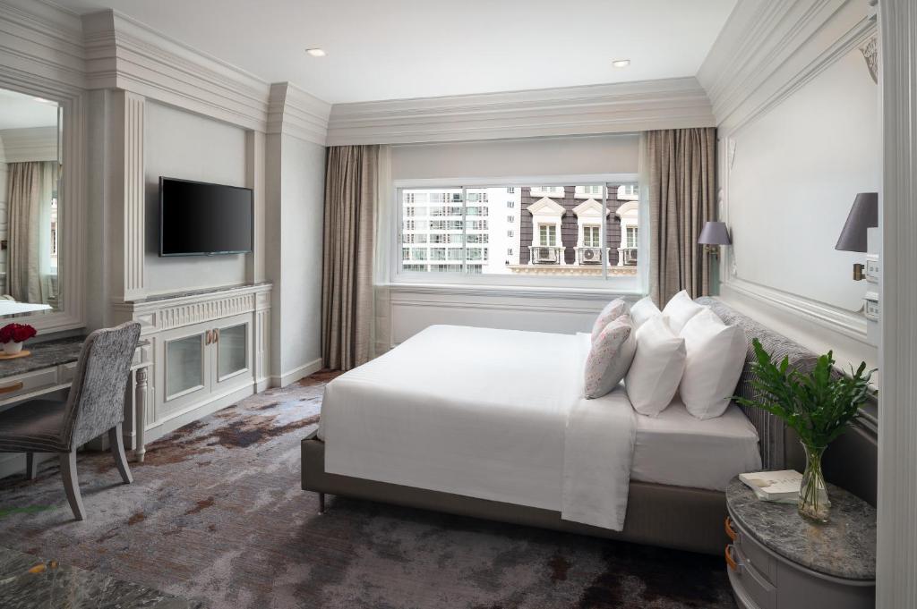 Kingston Suites Bangkok في بانكوك: غرفة نوم بسرير ومكتب وتلفزيون