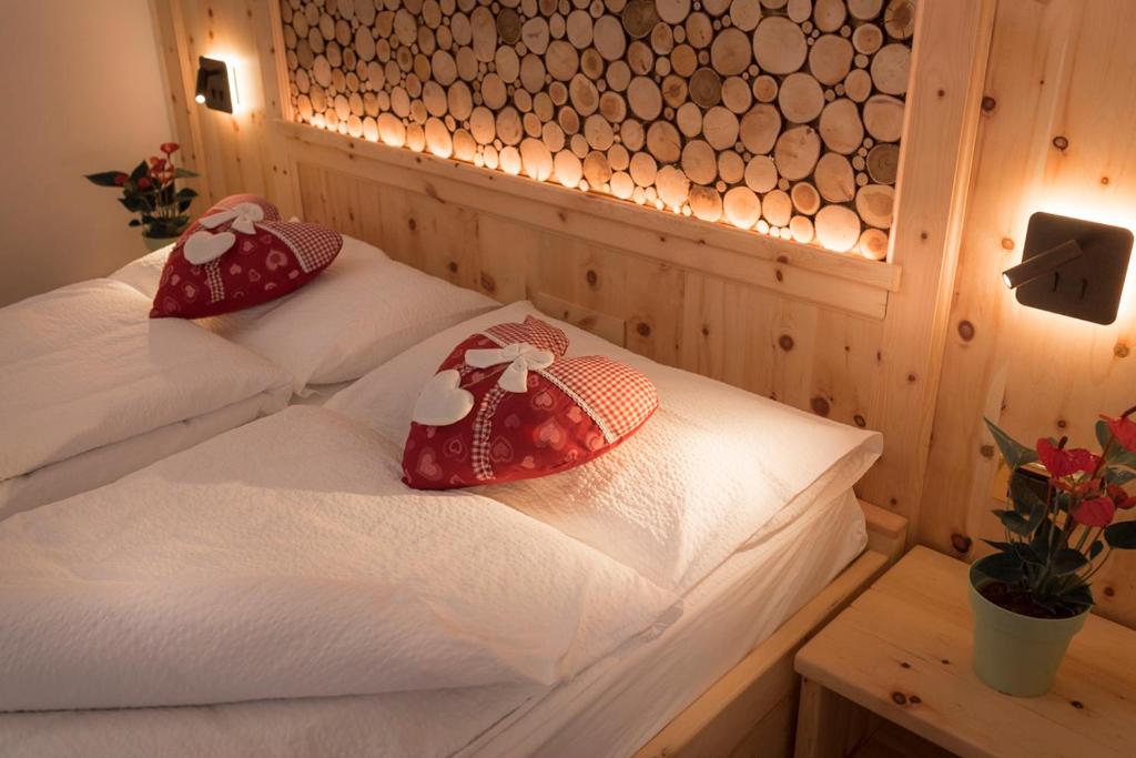 two twin beds in a room with a wooden wall at Garni Le Prealpi in Ledro