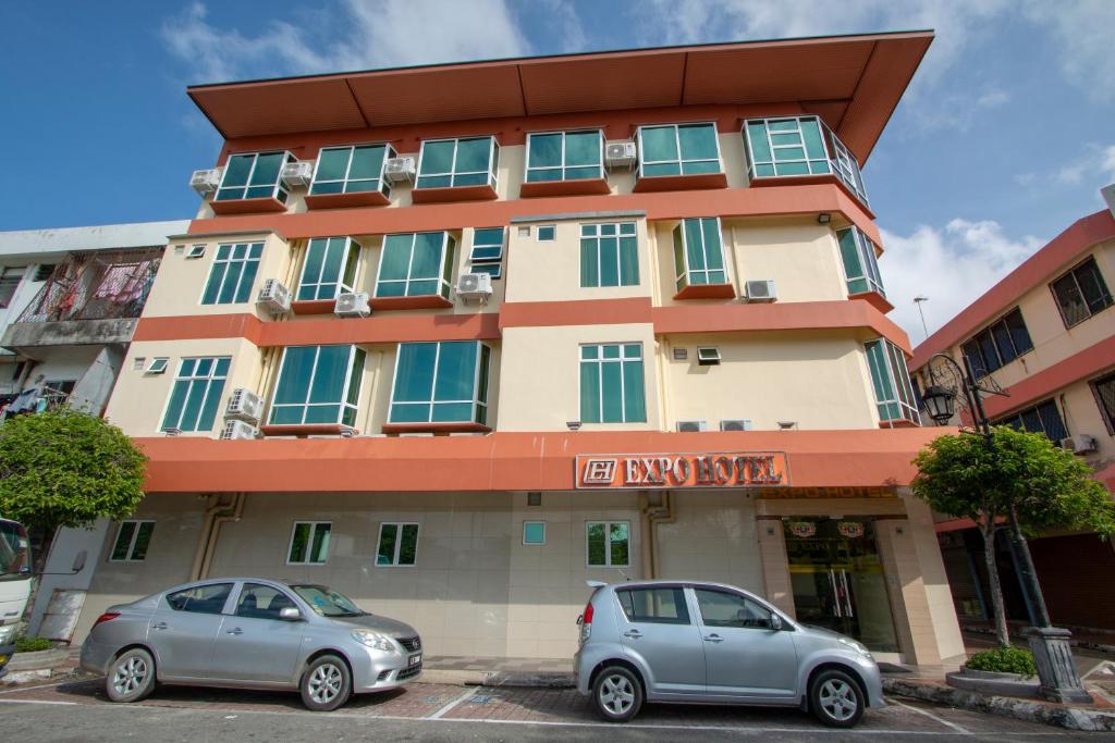 two cars parked in front of a building at Expo Hotel in Labuan