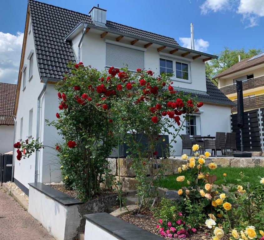 una casa blanca con flores delante en Rosenchalet en Leinach