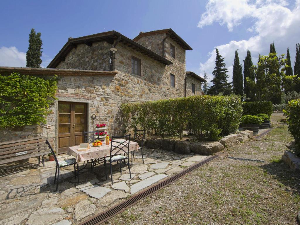 uma mesa e cadeiras em frente a uma casa de pedra em Belvilla by OYO Limone em Radda in Chianti