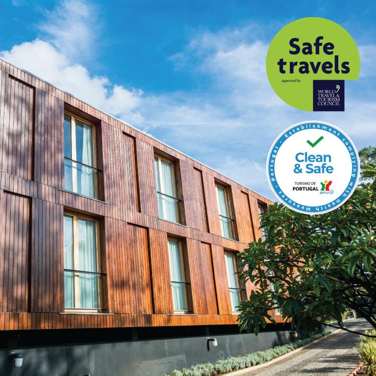a building with a sign that reads safe travels green and safe at ARTS IN Hotel Conde Carvalhal in Funchal