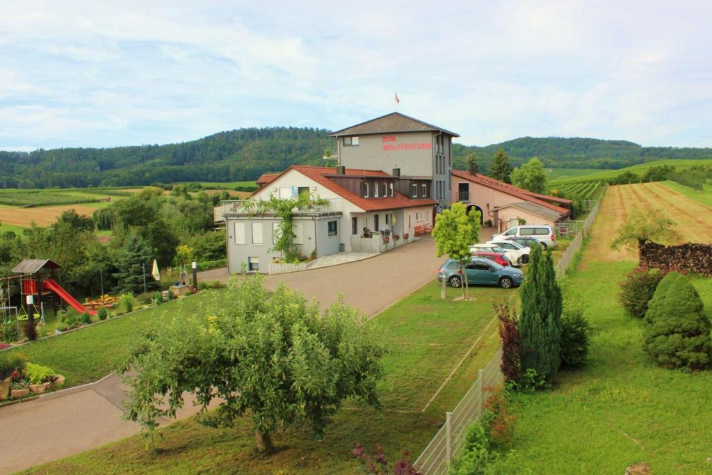 a house on a hill with cars parked on a road at Gaestehaus Zum Wolffenturm 