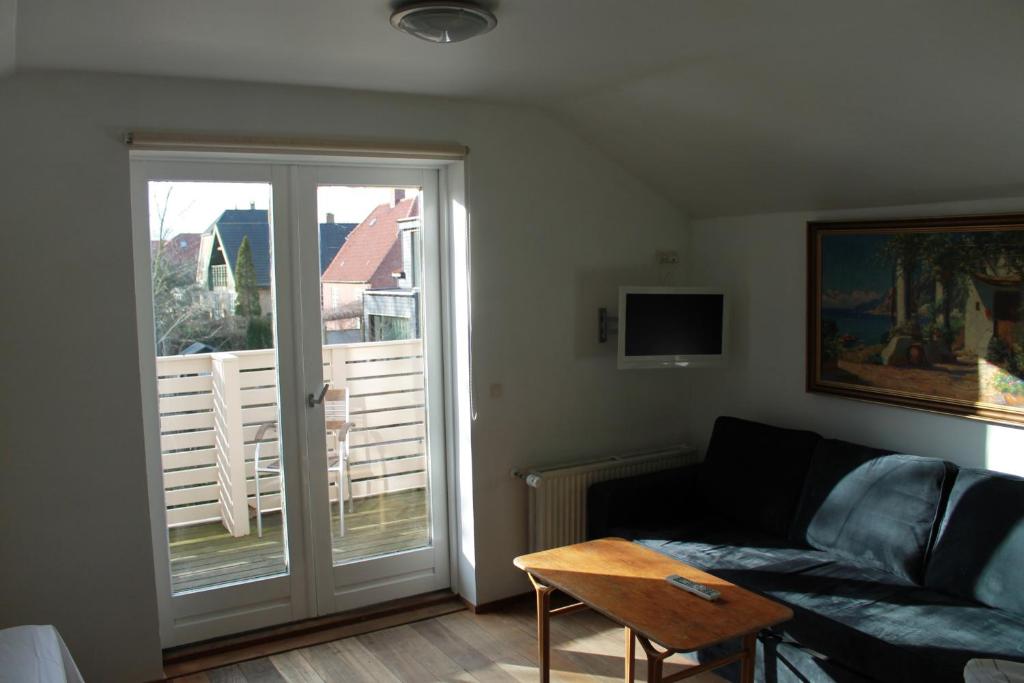 哥本哈根的住宿－拉維萊賓館，带沙发和滑动玻璃门的客厅